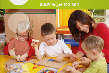 Eine Erzieherin spielt mit drei Kindern im Spielzimmer.