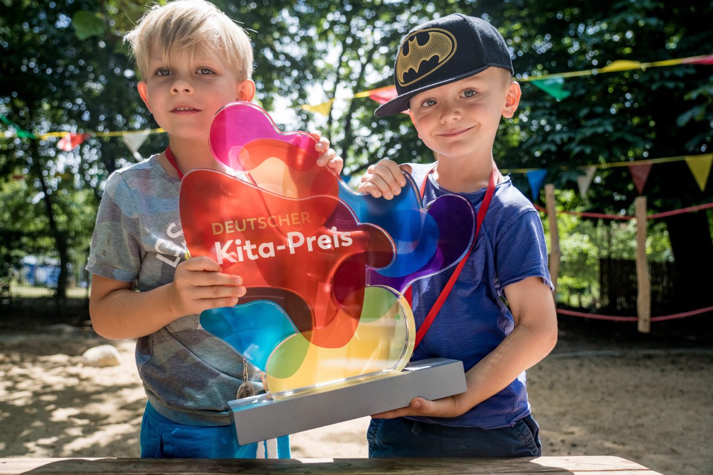 Zwei Kinder halten die Trophäe des Kita-Preises