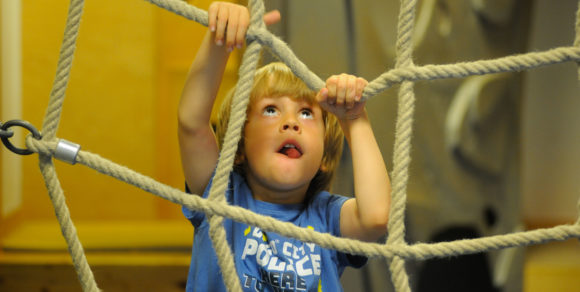 Der Junge Kyrylo kletter an einem Seilnetz empor.