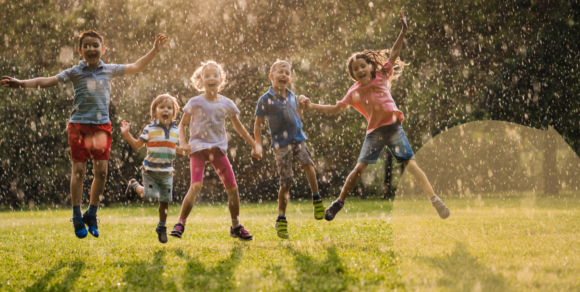 (Fünf Kinder zwischen etwa 3 und 6 Jahren springen ausgelassen auf einer Wiese in die Höhe.) Fünf Kinder zwischen etwa 3 und 6 Jahren springen auf einer Wiese in die Höhe.