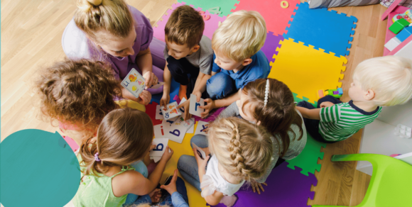 Foto: Kinder spielen mit ihrer Erzieherin ein Sprachspiel