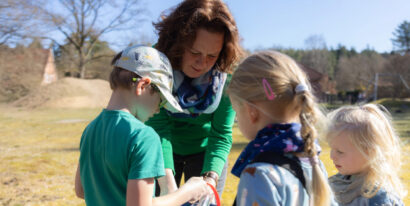 Sabine Pöhler schaut in die Eimer von drei Kindern.