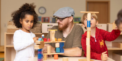 Patrick Lethen und zwei Kinder bauen mit Bausteinen.