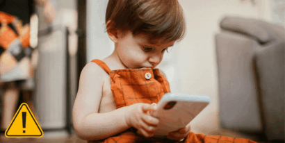 Kleines Kind blickt auf ein Smartphone.