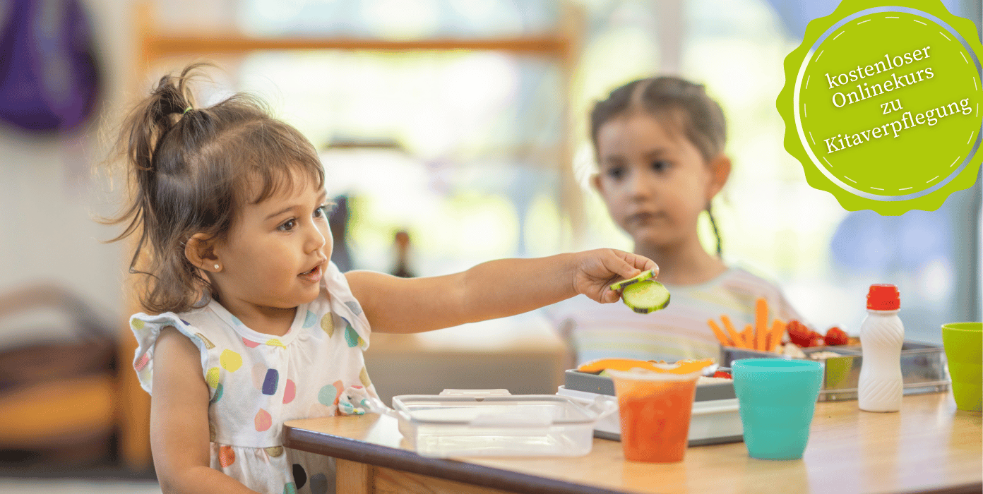 Gesunde Kitaverpflegung: Kind mit Gurkenscheibe beim Essen in der Kita