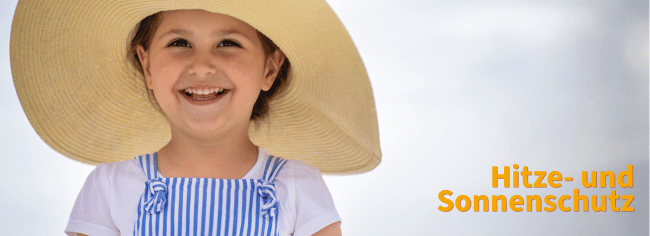 Ein fröhliches Kind mit großem Hut, das Hitze- und Sonnenschutz in Kindertageseinrichtungen symbolisiert.