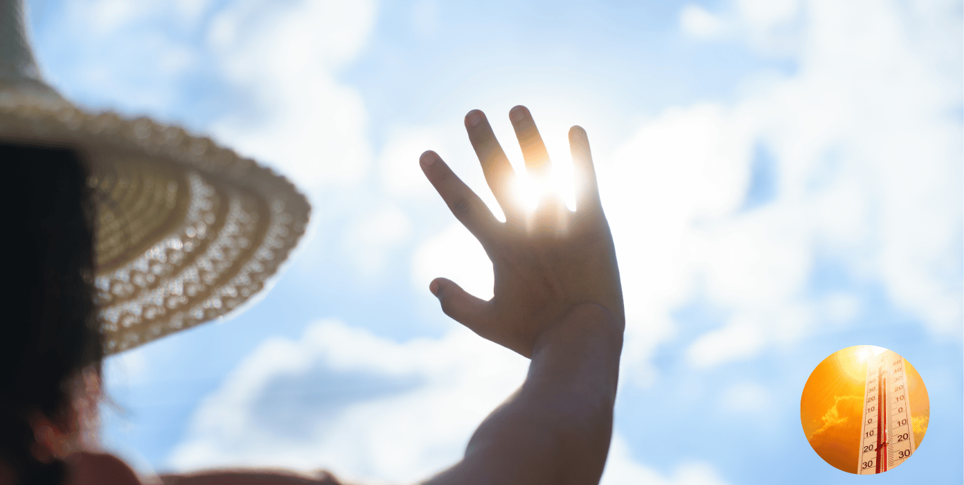Eine Hand blockiert die Sonne am Himmel, während ein Thermometer die Temperatur anzeigt.