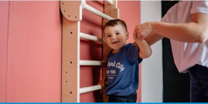 Ein Kind spielt an einer Kletterwand in der Kita, was die Aufsichtspflicht fördert und Sicherheit gewährleistet.