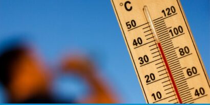 Ein Thermometer zeigt bei strahlend blauem Himmel eine hohe Außentemperatur von über 40 Grad Celsius an.
