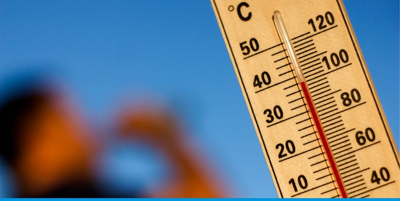 Ein Thermometer zeigt bei strahlend blauem Himmel eine hohe Außentemperatur von über 40 Grad Celsius an.