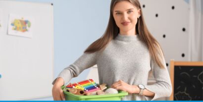 Junge Frau in einem Raum mit Spielzeugkiste, die Holzspielzeug und Musikinstrumente enthält.