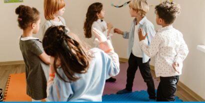 Sechs Kinder diskutieren aktiv in einem Raum.