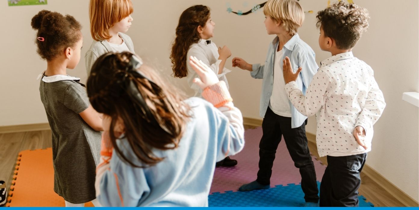 Sechs Kinder diskutieren aktiv in einem Raum.