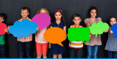 Eine Gruppe von Kindern hält bunte Sprechblasen vor sich.